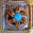 Detailed Close-Up of Blue Gemstone Surrounded by Gold Petals