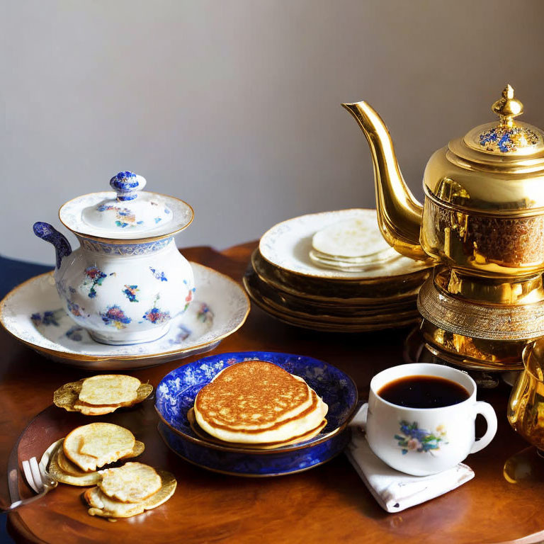 Golden teapot, tea cup, fluffy pancakes, plates, and sugar bowl on wooden table