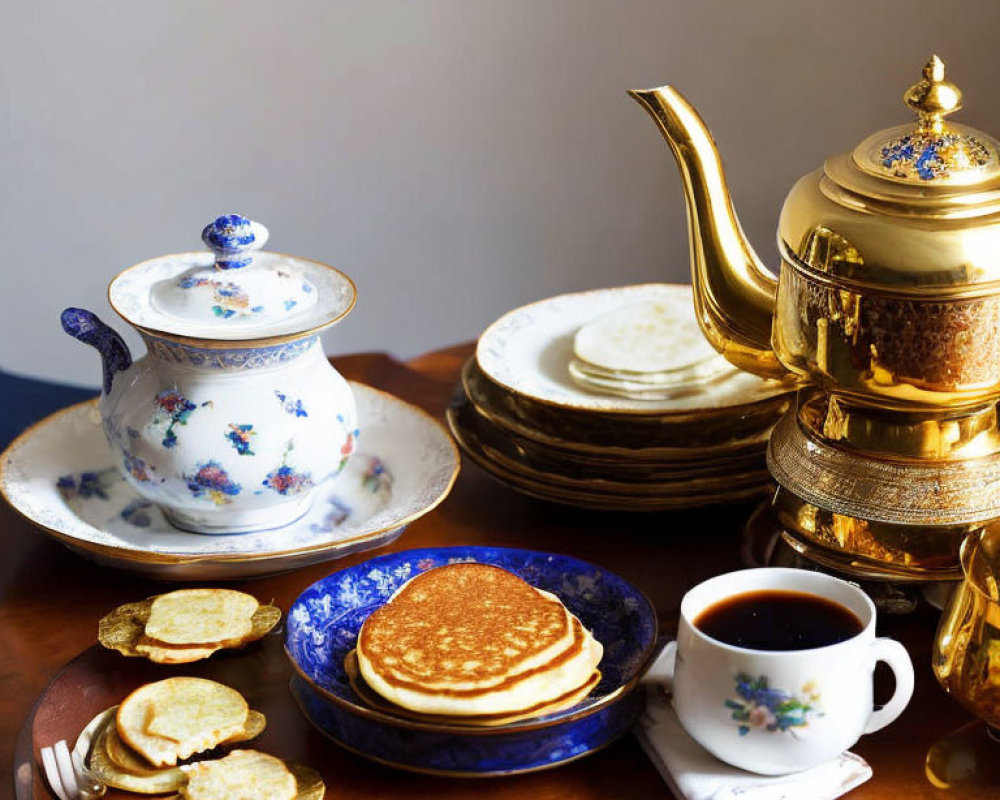 Golden teapot, tea cup, fluffy pancakes, plates, and sugar bowl on wooden table