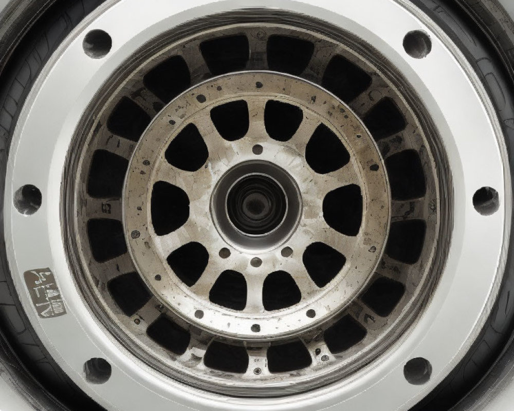 Dirty car wheel with silver rim and black tire in close-up view