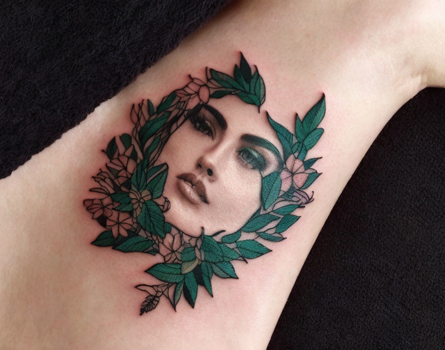 Detailed Woman's Face Tattoo with Leaves and Flowers on Black Skin