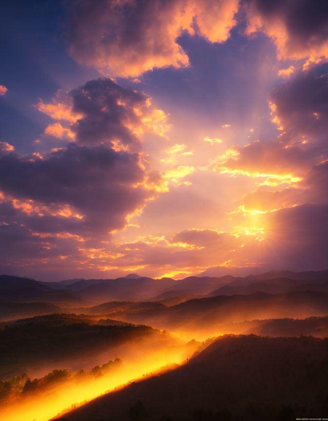 Majestic sunrise with golden rays over misty mountain landscape