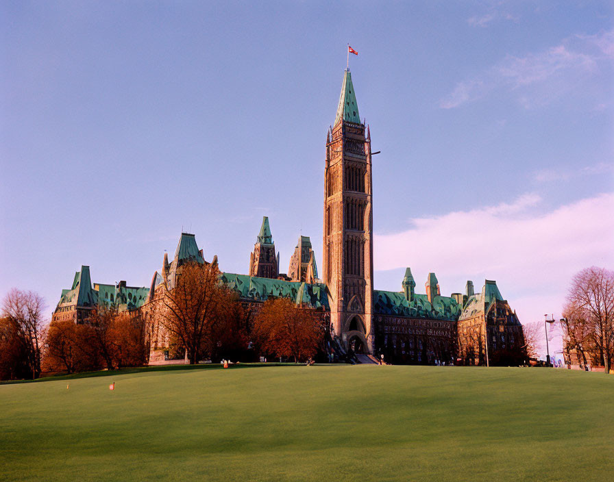 Gothic-style building with towering spire in green landscape