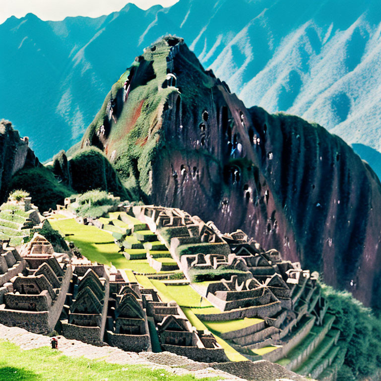 Ancient stone ruins and terraced slopes of Machu Picchu with mountain backdrop in lush green setting