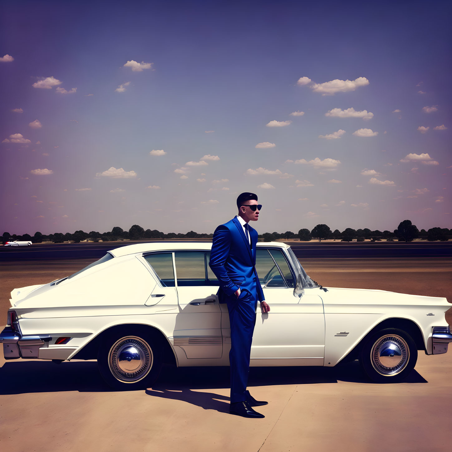 Man in Blue Suit Standing Next to Classic White Car Under Clear Sky