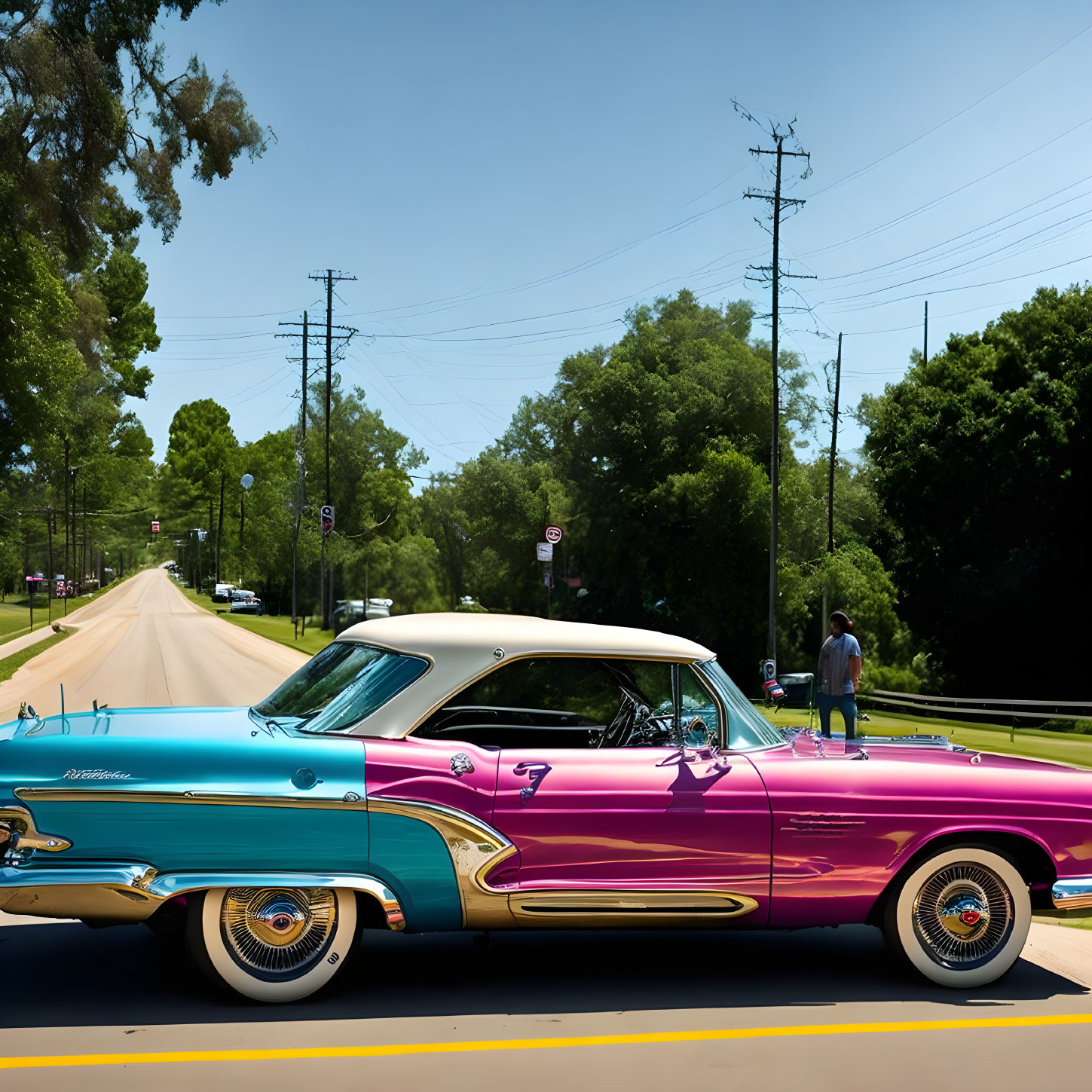 Vintage pink and blue car with white-wall tires parked on street with person in background