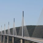 Modern cable-stayed bridge with multiple pylons and harp-like cables over valley and mountains