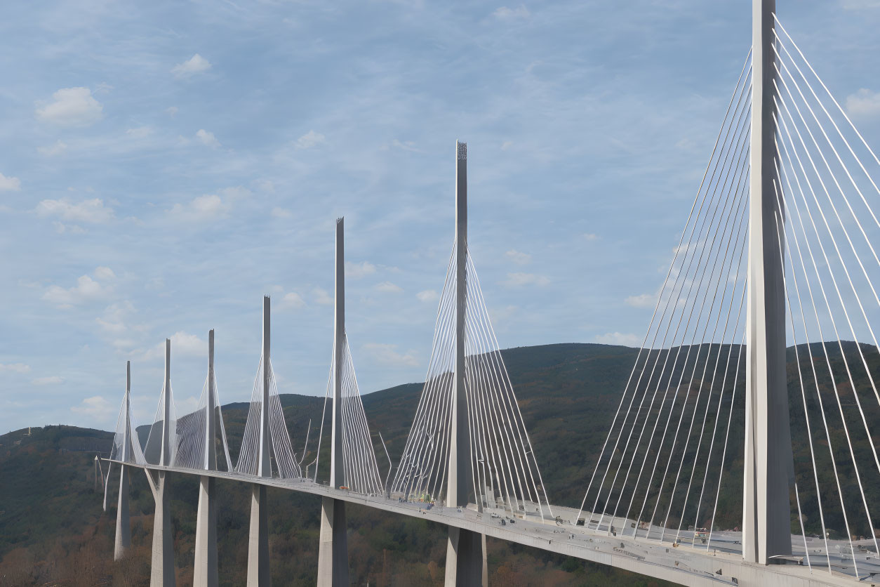 Modern cable-stayed bridge with multiple pylons and harp-like cables over valley and mountains