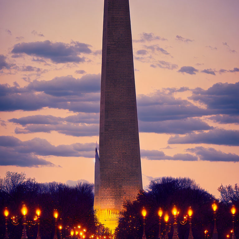 Tall Obelisk Monument at Twilight with Trees and Street Lamps