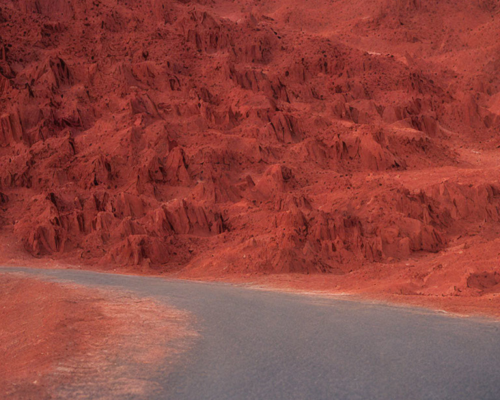 Curving road with red rocky terrain resembling Martian landscape