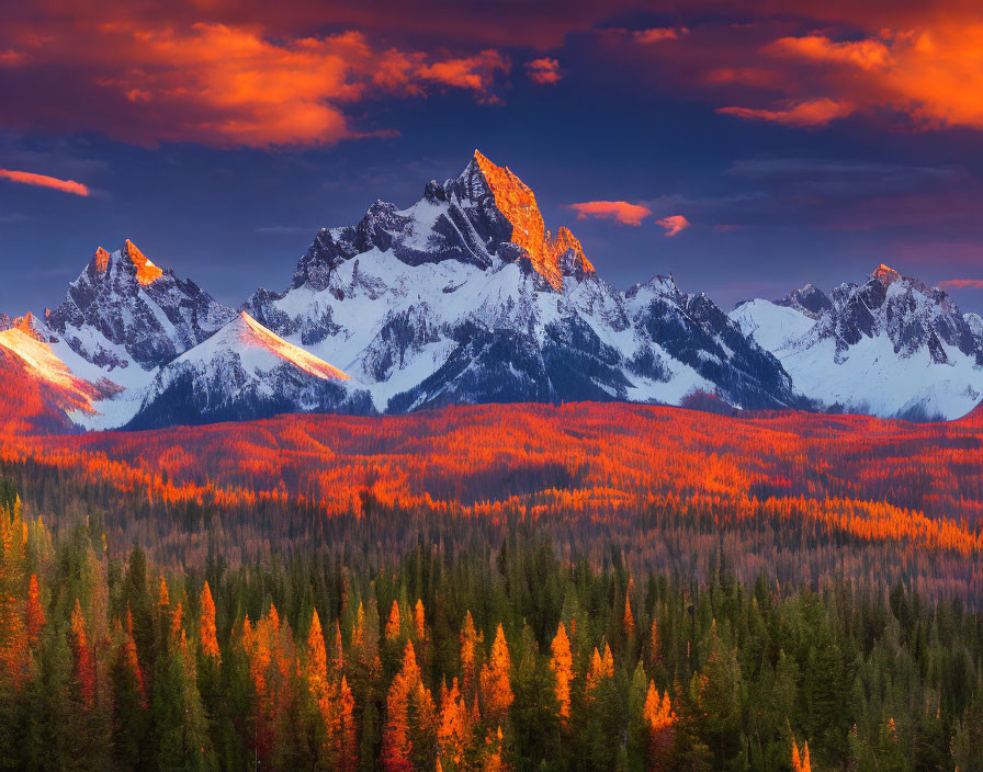Snow-capped mountains under fiery sunset with vibrant forest.