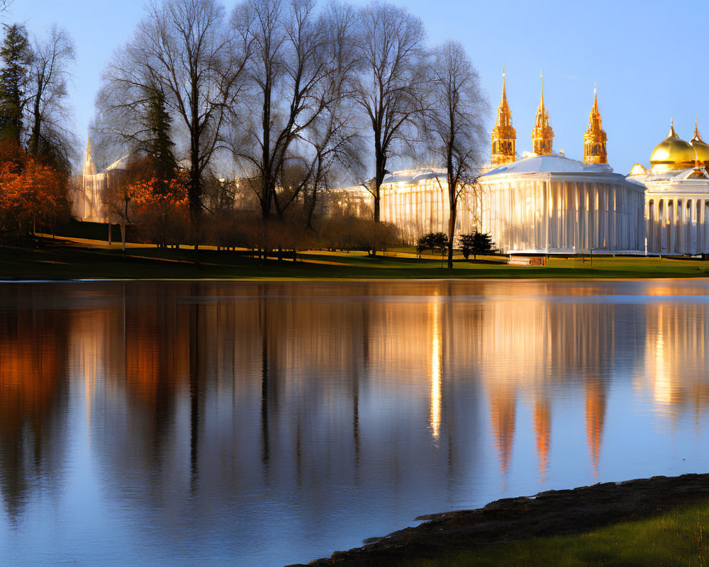 Golden-domed buildings and trees reflected in calm waters at tranquil dusk