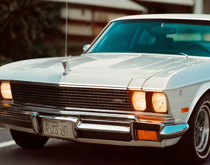 Vintage Silver Ford Car with Headlights On and Classic Design Outdoors