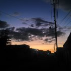 Vibrant Sunset Silhouetting Buildings and Tower in Orange Glow