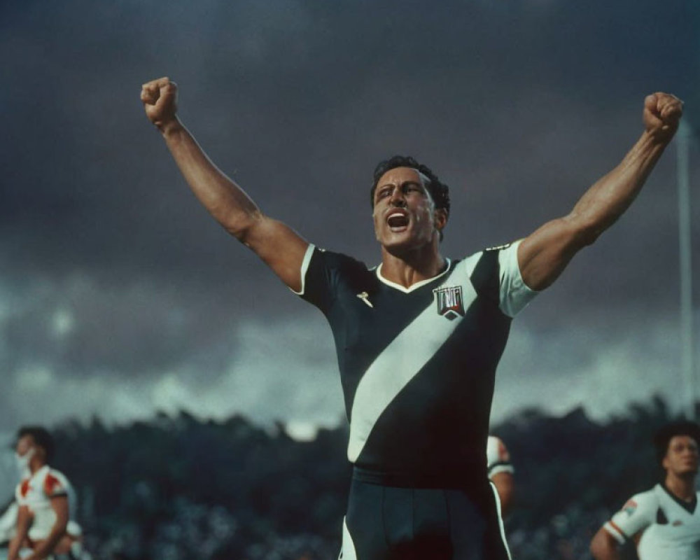 Athlete in Black and White Uniform Celebrates Victory on Sports Field