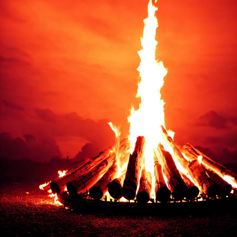 Intense Flames and Glowing Embers in Large Bonfire at Dusk