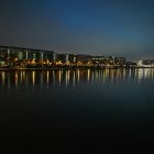 Bright cityscape with star-filled sky over illuminated urban area.