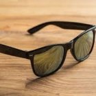 Black Sunglasses with Multicolored Reflective Lenses on Textured Golden Surface