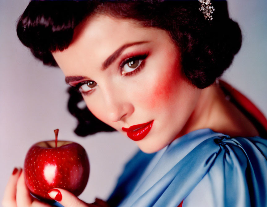 Vintage-Style Portrait of Woman with Dark Hair, Red Lipstick, Holding Red Apple in Blue Out