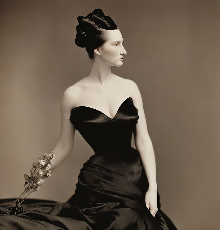 Vintage black strapless gown and feathered hairpiece in sepia-toned portrait