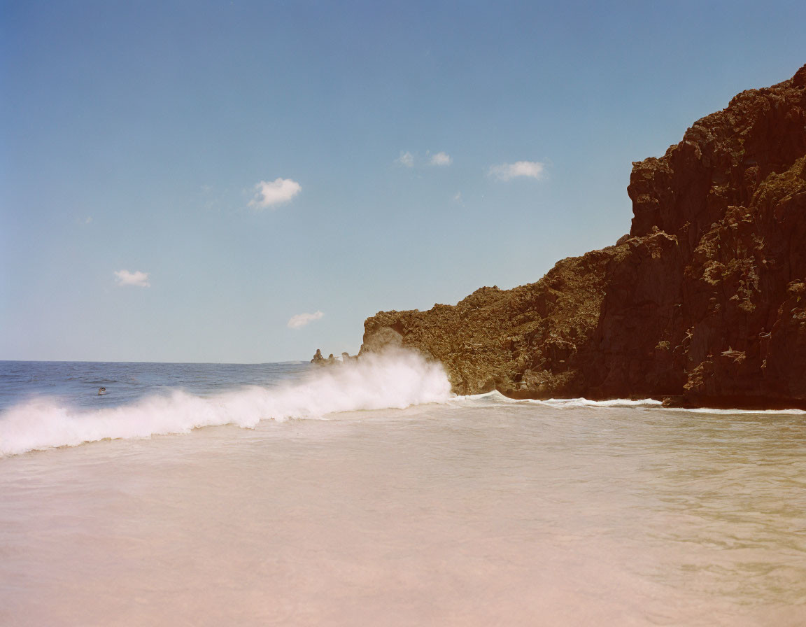 Tranquil beach scene with gentle waves and rocky cliffs