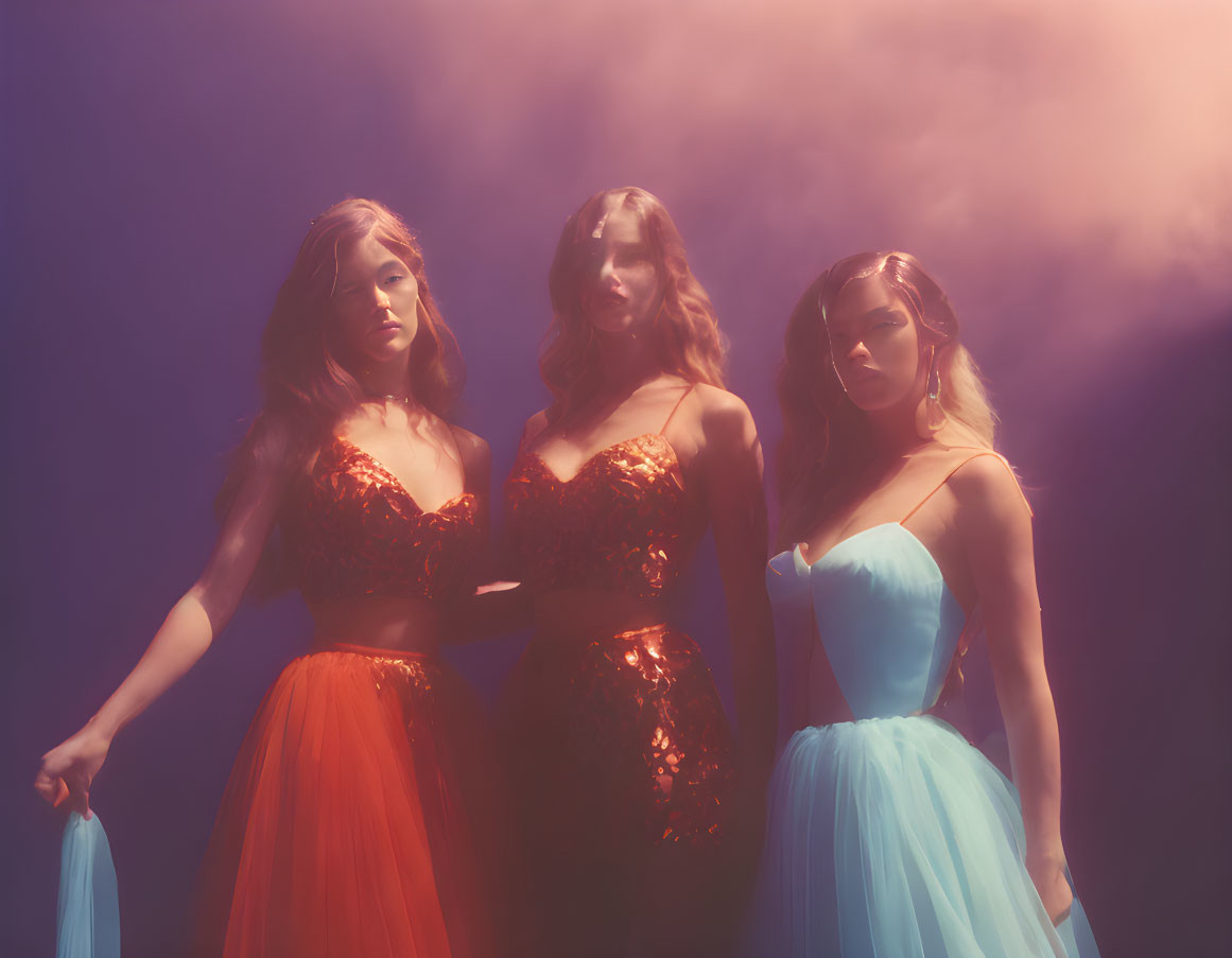 Three women in elegant dresses in misty, colorful setting with blue and purple gradient.