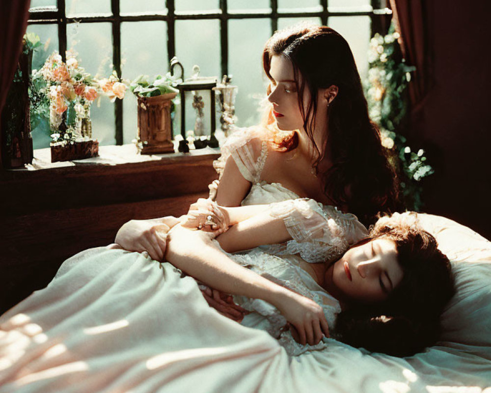 Two women in vintage dresses on bed with sunlight and flowers