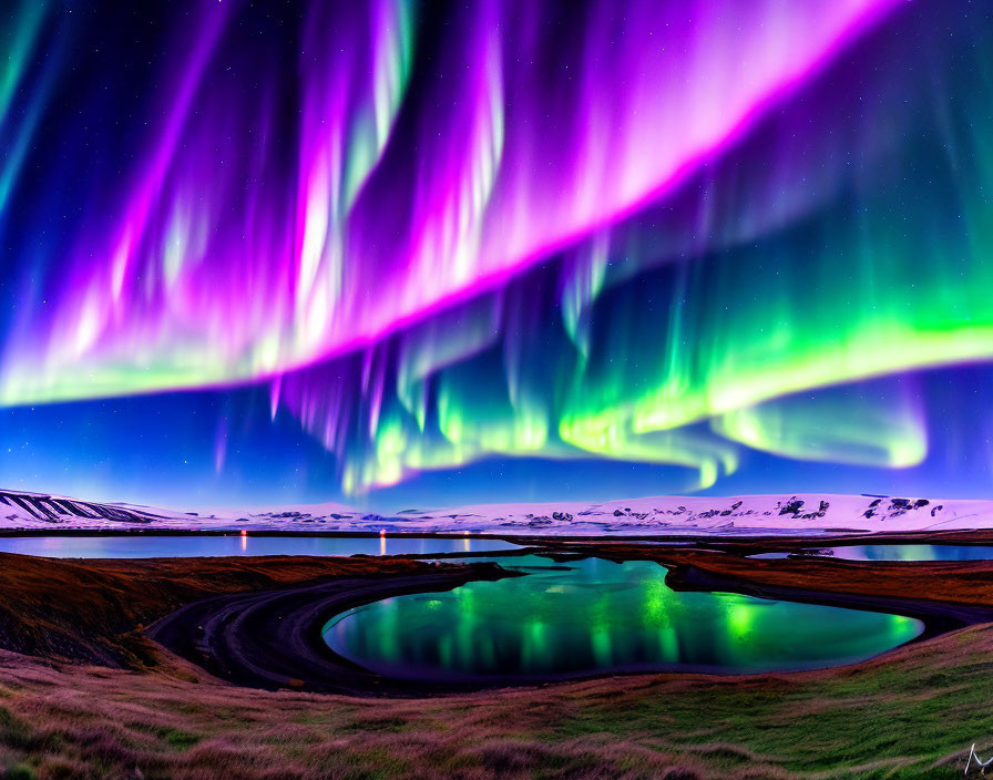 Majestic aurora borealis over snowy mountains and waterway