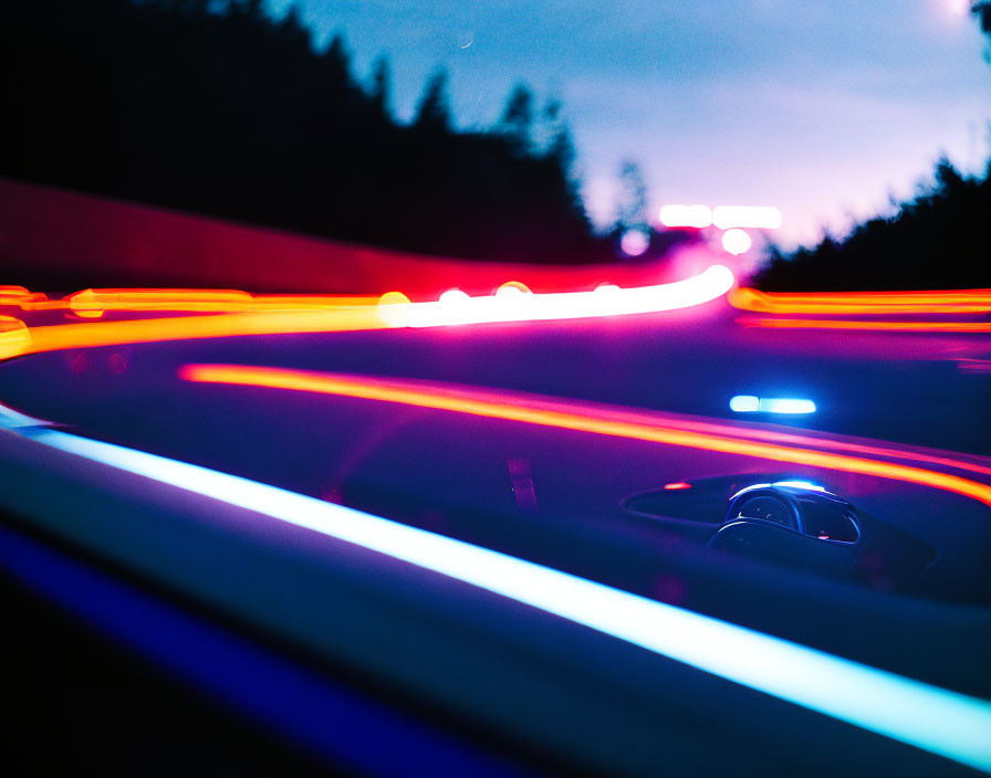 Colorful light streaks on car dashboard at night convey speed & motion