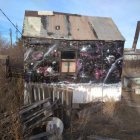 Post-apocalyptic scene: two people, dog, dilapidated car, faded billboard, ruins,