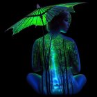 Surreal image: Woman in meditative pose with forest silhouette and luminous green butterfly wing