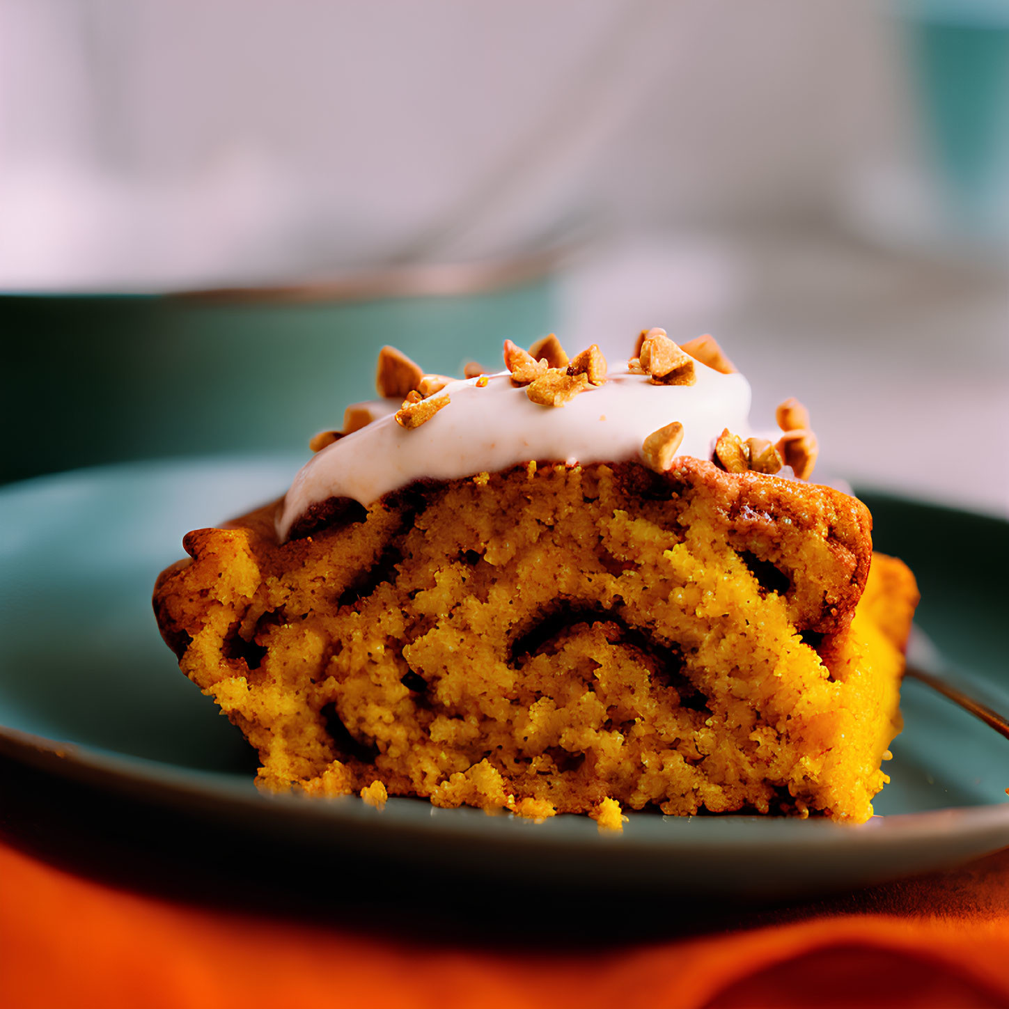 Marble cake slice with white icing and nuts on dark plate