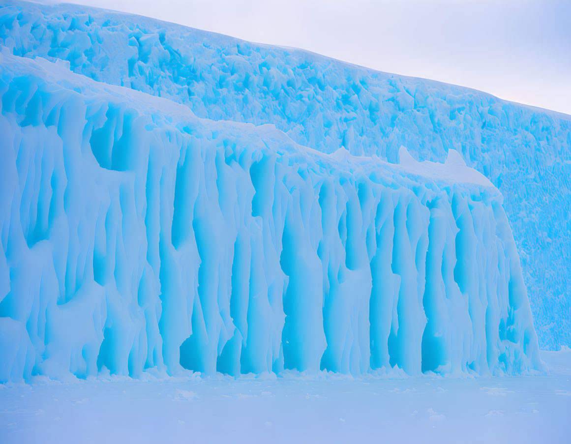 Towering Blue Ice Wall Under Soft Pastel Sky