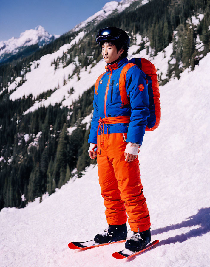 Skier in Orange and Blue Gear on Snowy Slope