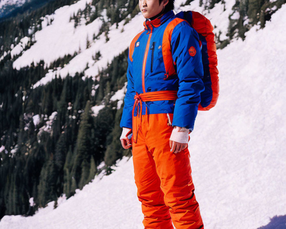 Skier in Orange and Blue Gear on Snowy Slope