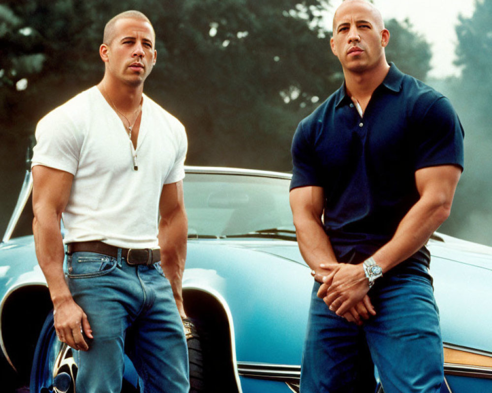 Muscular men in white and blue shirts pose by classic car