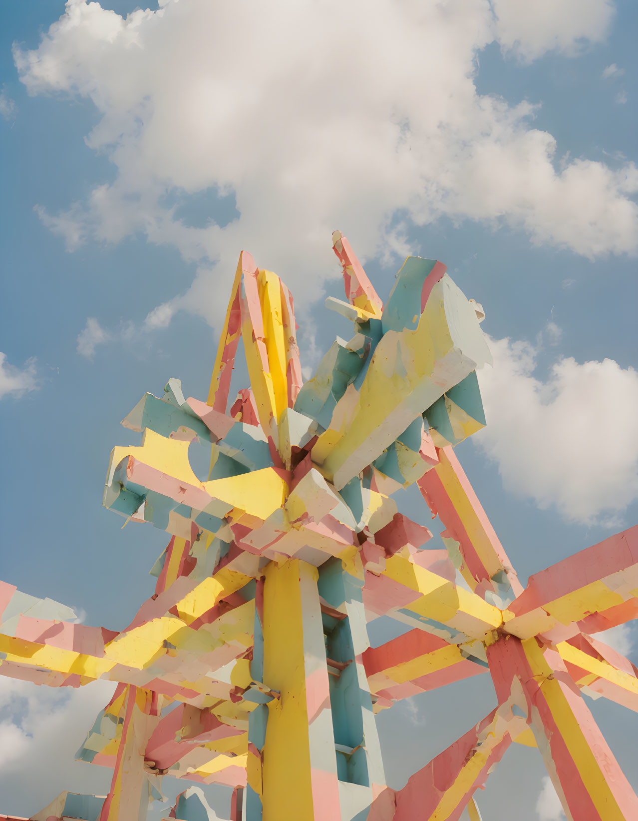 Multicolored abstract sculpture against blue sky with clouds