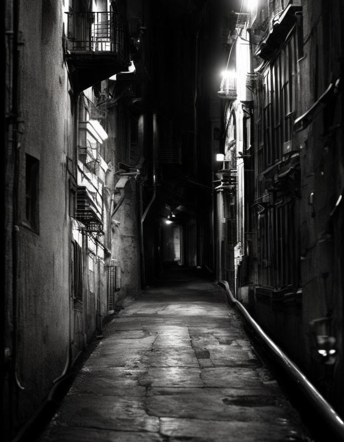 Dimly Lit Alley Between Tall Buildings at Night