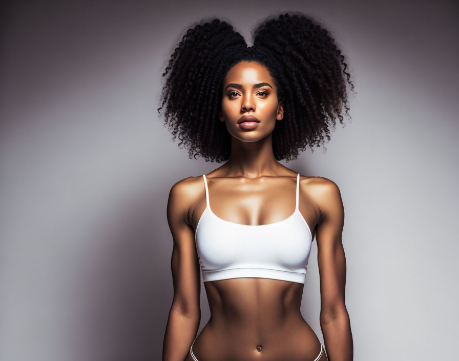 Curly-Haired Woman in White Sports Bra Poses Confidently