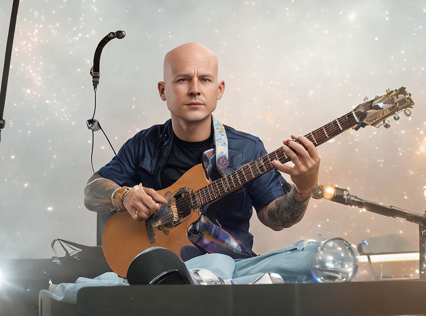 Bald Musician Performing with Acoustic Guitar on Stage