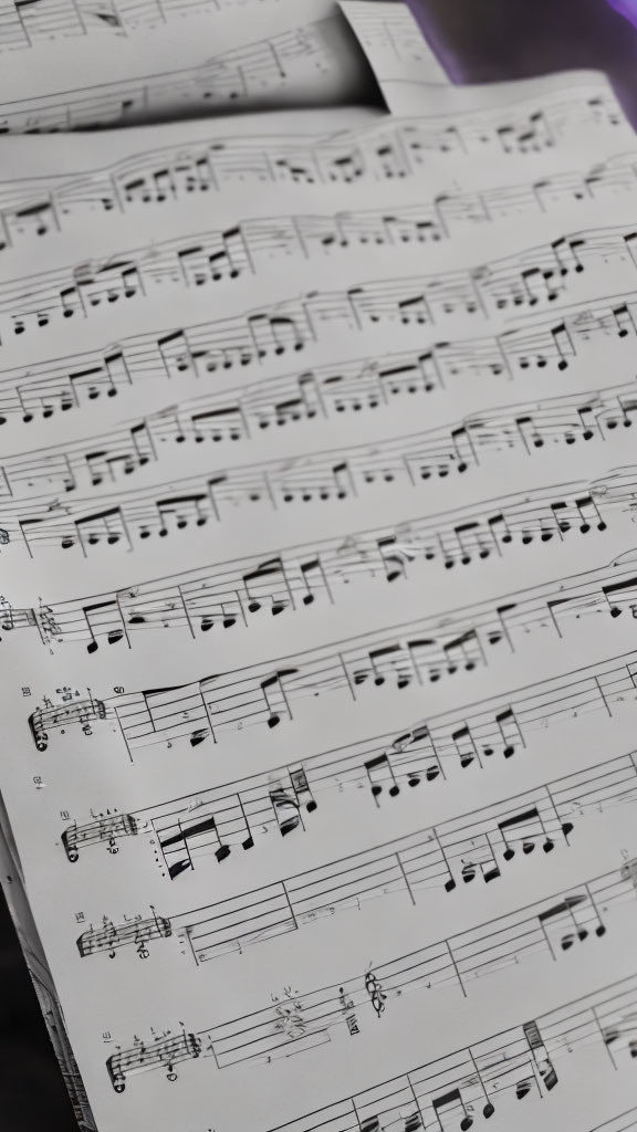 Detailed close-up of black musical notations on lined staves with blurred background