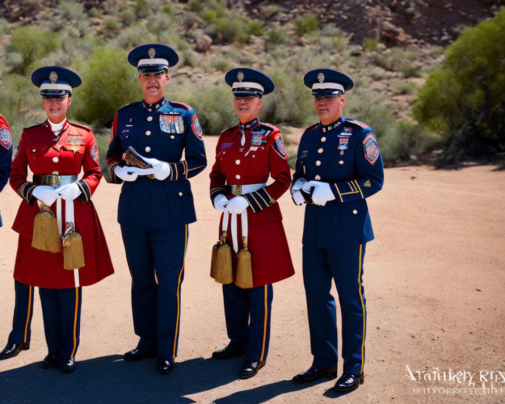 Four uniformed individuals in ceremonial attire outdoors with red and blue jackets, white gloves, and embellished