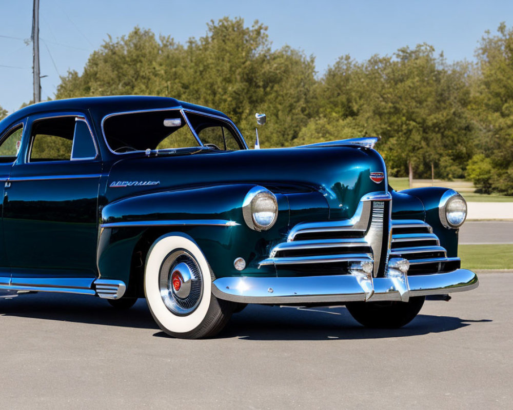 Vintage blue Chevrolet parked on asphalt with white wall tires