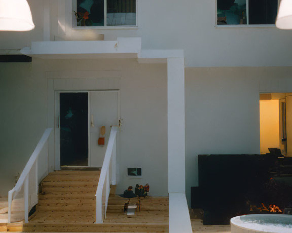 Two-story home interior with open staircase, light wood floors, white walls, hanging lights, and warmly