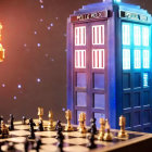 TARDIS-shaped model on chessboard with police box design, illuminated with bokeh effect.