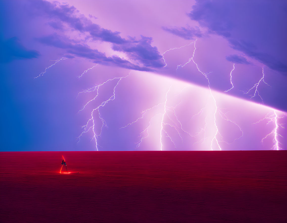 Person in red desert under purple sky with lightning bolts