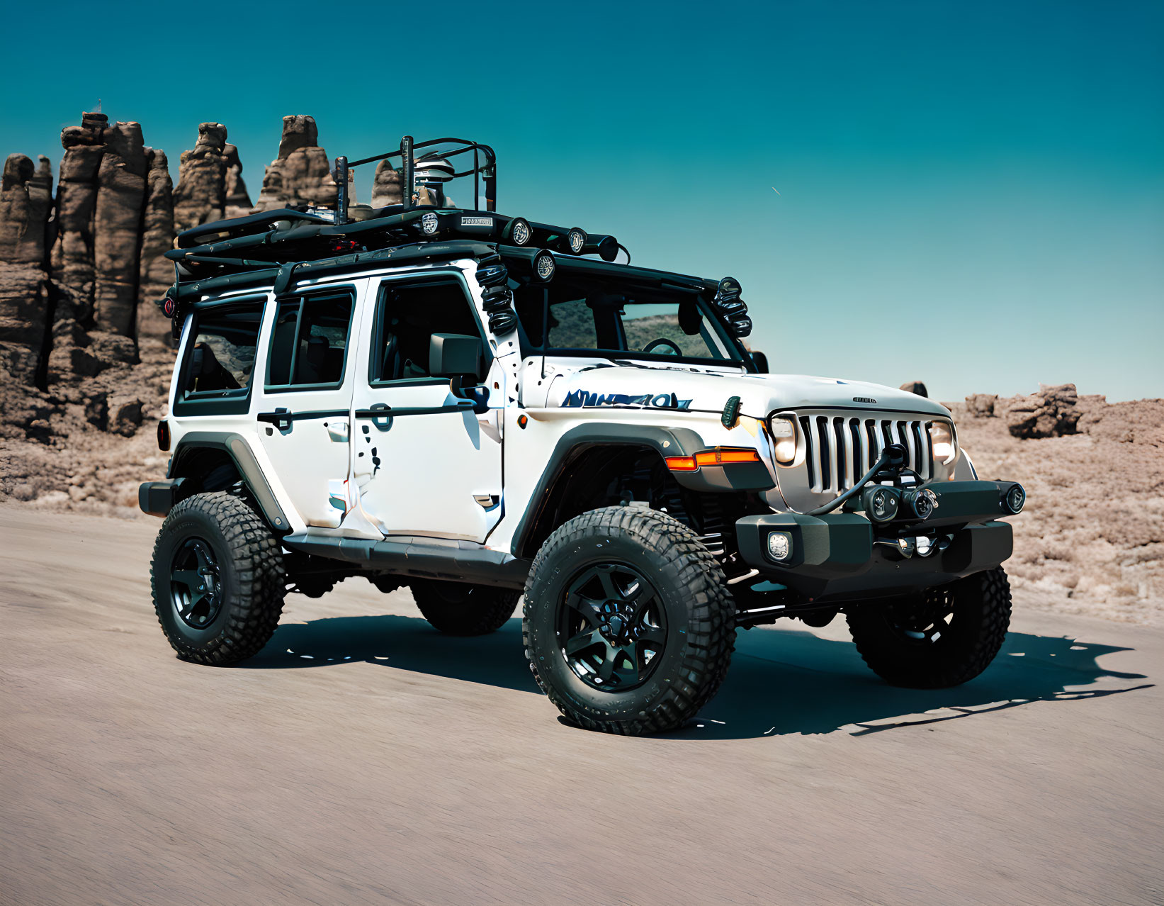 White off-road vehicle with roof rack in desert landscape.