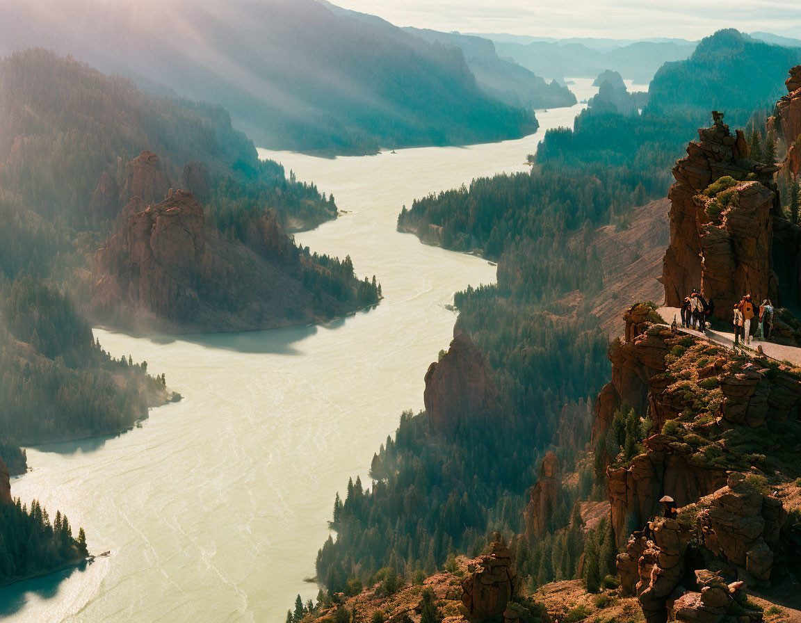 People on Cliff Overlooking Winding River in Lush Valley