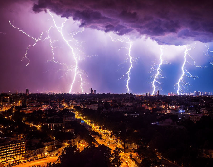 Intense lightning storm over cityscape at night