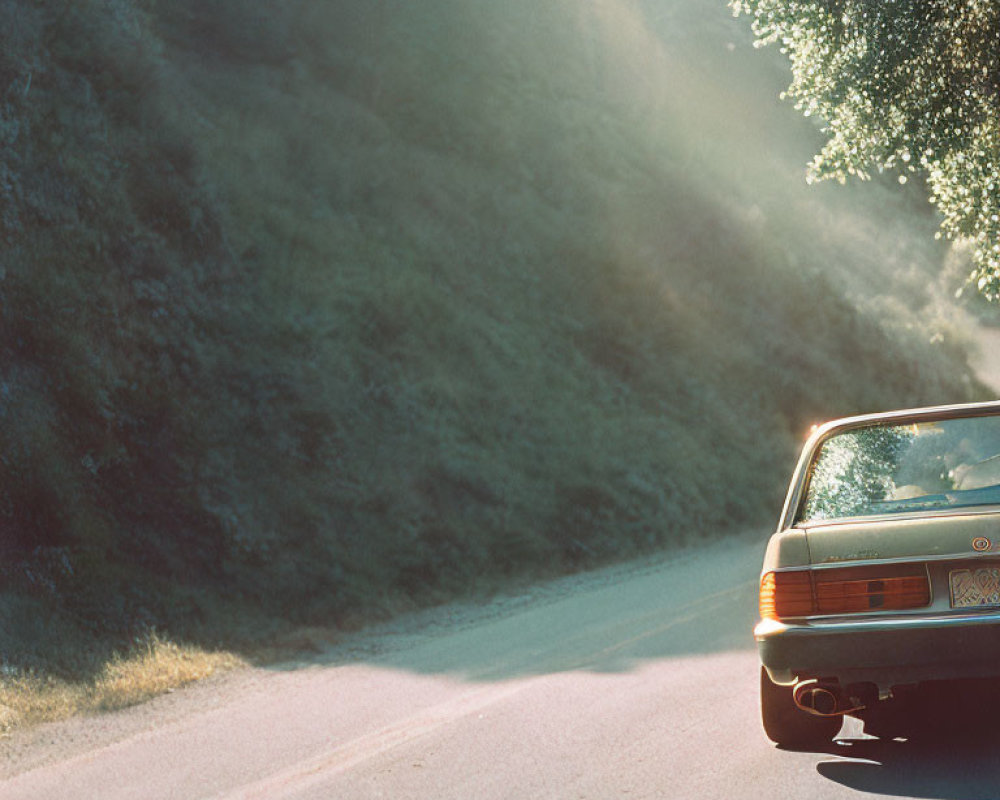 Vintage Car on Sunlit Forest Road with Peering Sun Rays